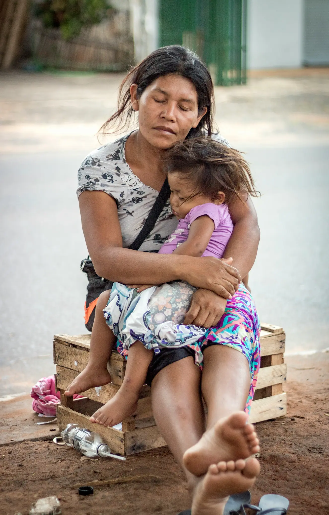 Mother and daughter sit behind the road